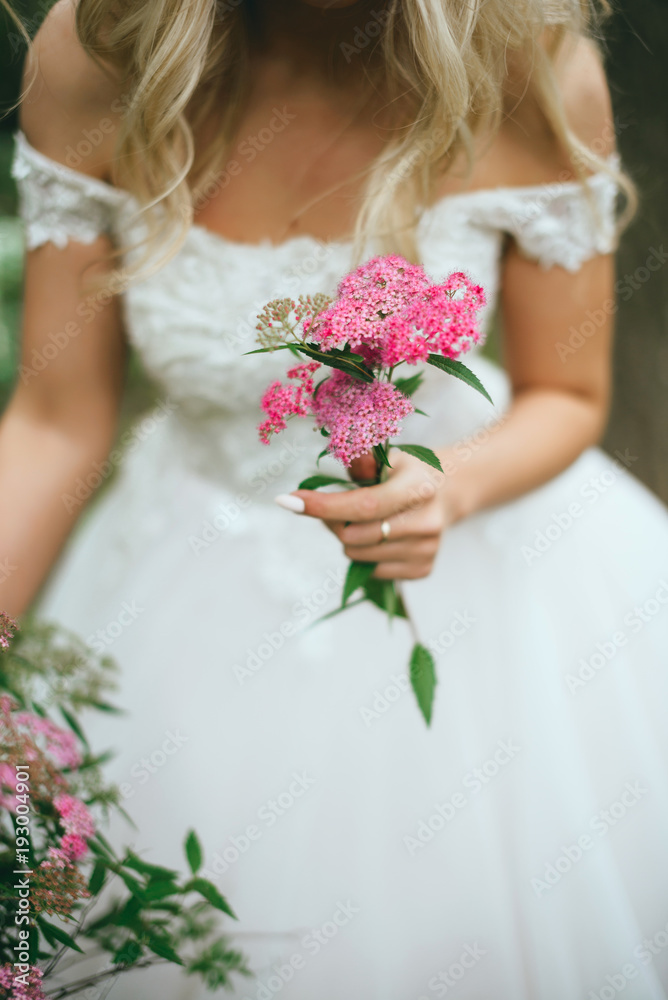 bride in nature with a beautiful wedding bouquet