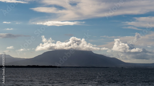 Zoom on Mount Isabel de Torres with bright clouds during a beautiful day in Puerto Plata. The picture was taken from Sosùa, Dominican Republic.