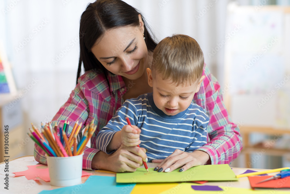 teacher woman drawing with child boy in a classroom teacher woman drawing with child boy in a classroom