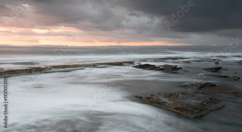 Rocky seashore seascape with wavy ocean during sunset © Michalis Palis