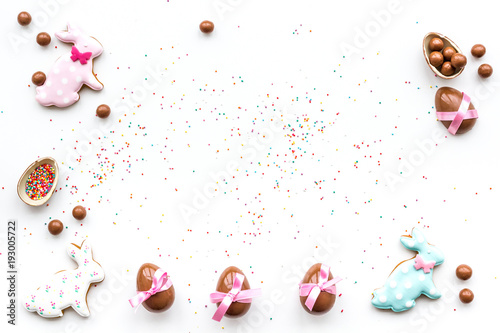 Celebrate Easter. Modern signs of Easter. Chocolate Easter eggs and Easter bunny cookies. White background top view copy space