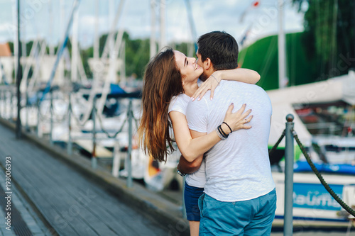 loving couple hugging on pier in summer