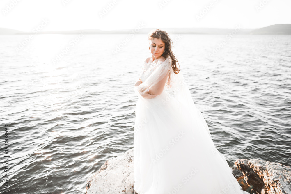 Beautiful young bride posing on the background sea Beautiful young bride posing on the background sea