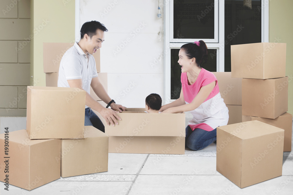 Young Asian family unpacking boxes in their new home Young Asian family unpacking boxes in their new home