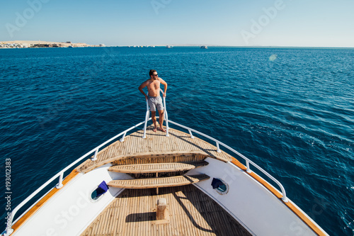 Man on a yacht. Beautiful view from a bow of a yacht at seaward. Sailing. Luxury yachts. Summer vacation and voyage concept © F8  \ Suport Ukraine