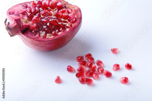Pomegranate seeds and Beautiful ripe pomegranate on white background with place for copy space. photo