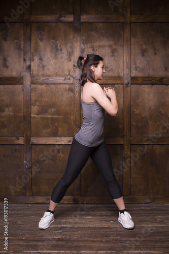 Full length portrait of brunette girl. Training in gym.