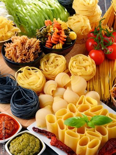 Composition with different sorts of pasta on kitchen table