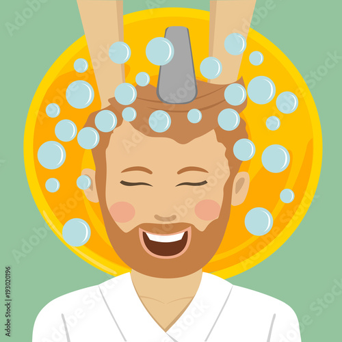 Young bearded man in barbers getting washed his hair with shampoo