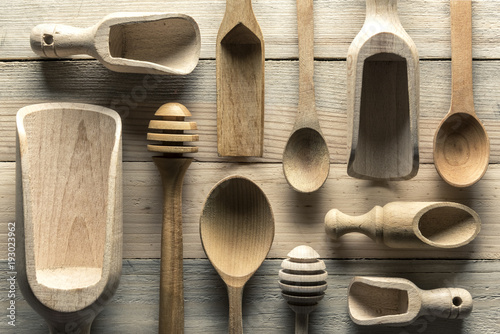 Different wooden utensils on wooden table closeup. Natural food texture background