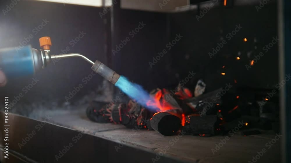 Ignition of charcoal in the barbecue oven using a gas burner