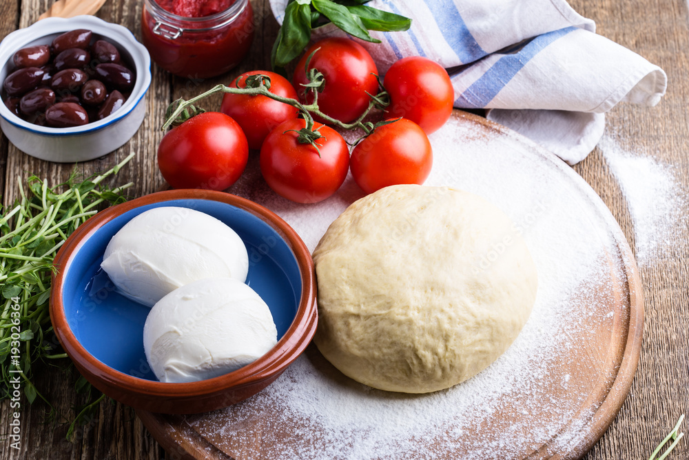Fototapeta premium Making pizza. Pizza dough with ingredients