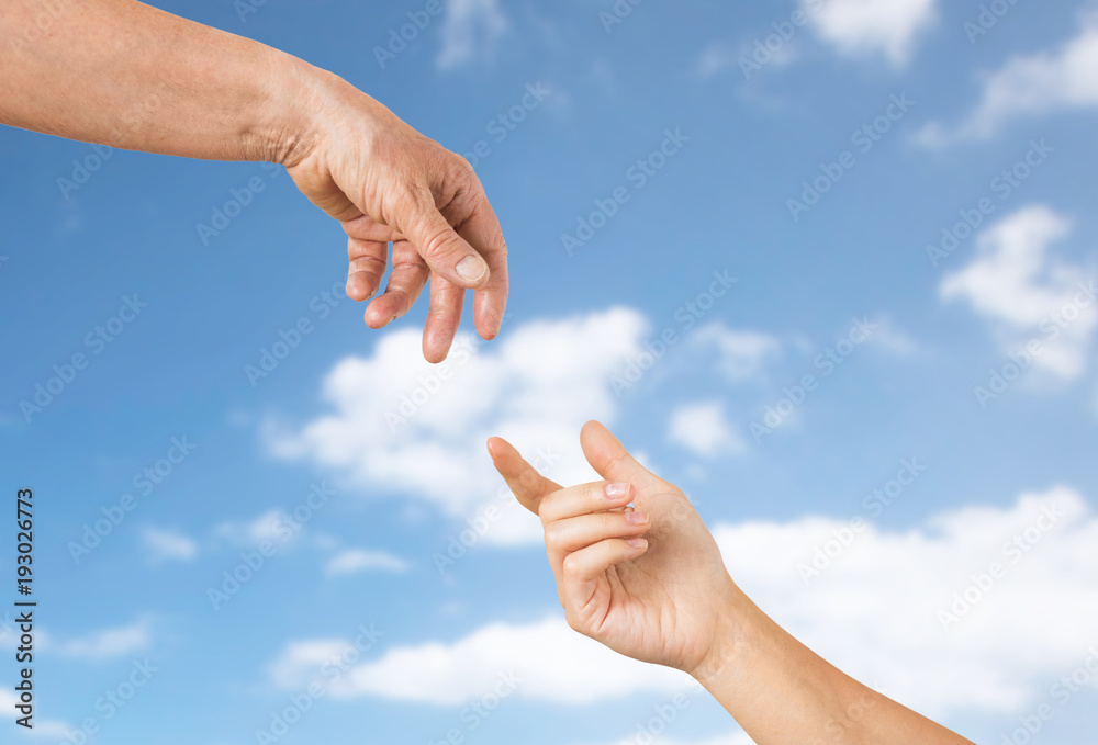 close up of senior and young woman hands over sky close up of senior and young woman hands over sky