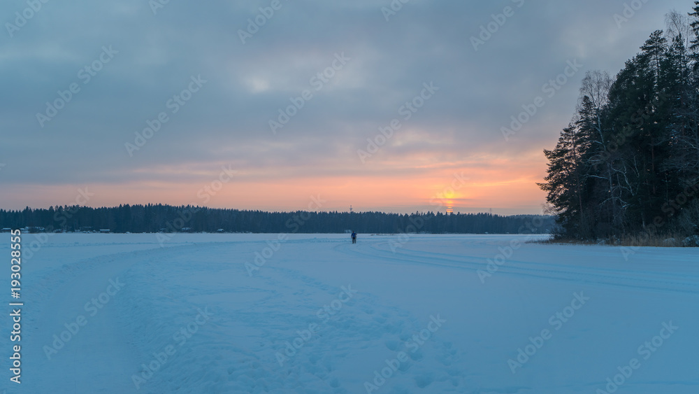 Sunset over a snow covered lake in winter Sunset over a snow covered lake in winter