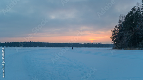 Sunset over a snow covered lake in winter
