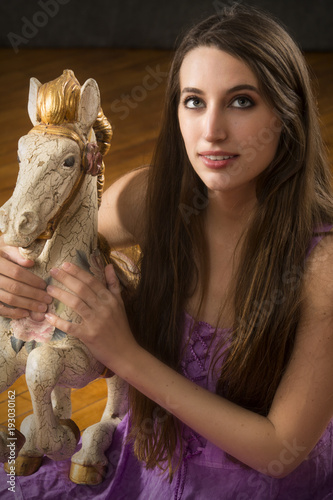 Portrait of young woman and antique carousel horse.