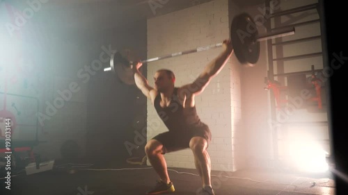 the athlete trains in the gym, raises the bar