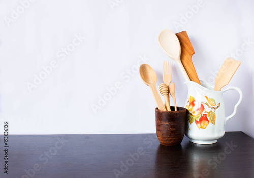 Kitchen utensils and dishware on dark table over white background. Kitchen interior background