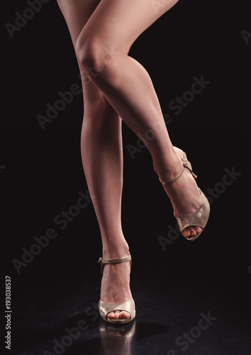 woman legs in shoes on black background