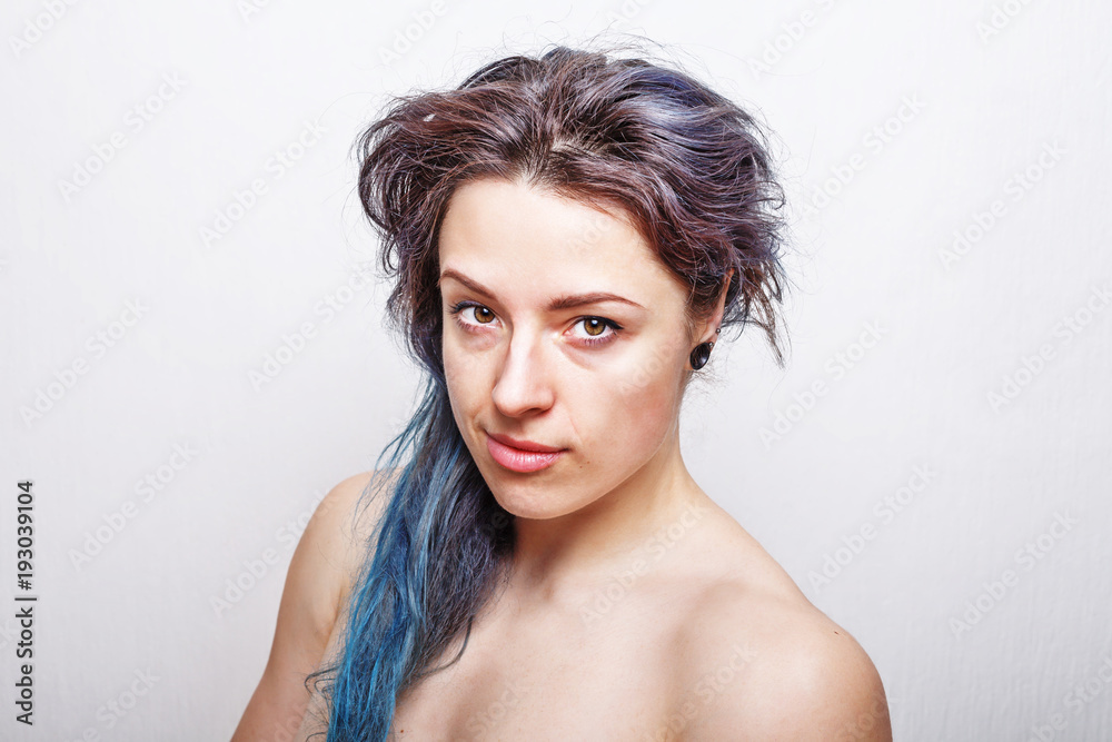 Clean portrait of a thirty year old woman with messy hair dyed in violet and turquoise colors. Clean portrait of a thirty year old woman with messy hair dyed in violet and turquoise colors.