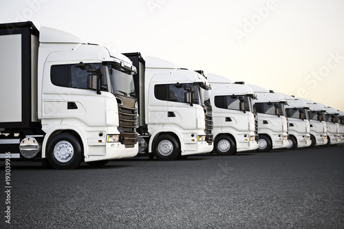 Canvas Print Fleet of white commercial transportation trucks parked in a row ready for business distribution