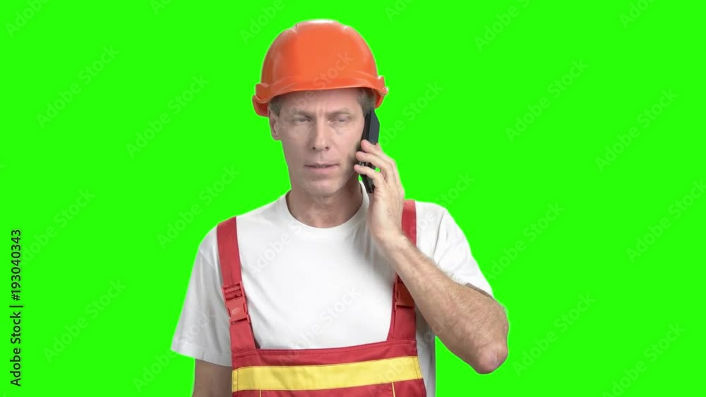 Construction worker talking on cell phone. Mature foreman talking on mobile phone on chroma key background. Confident foreman with mobile phone. Construction worker talking on cell phone. Mature foreman talking on mobile phone on chroma key background. Confident foreman with mobile phone.