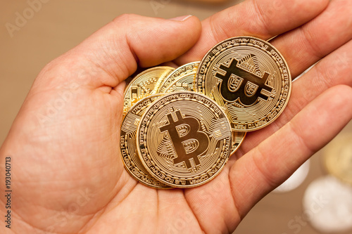 golden bitcoin coins in the hand photo