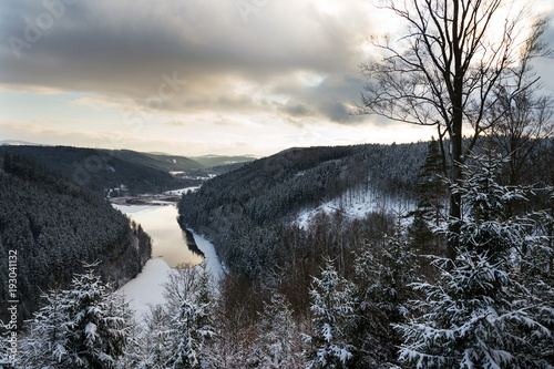 Aerial view of concrete Brezova dam with hydroelectric power plant and road to Karlovy Vary from Jungmann gazebo, snowy winter day, Czech Republic photo
