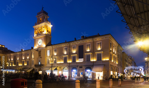 Parma city hall illuminated at dusk and monument