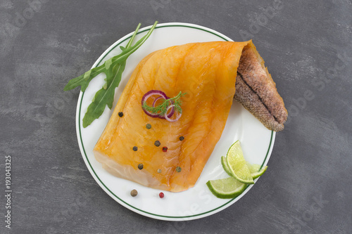 Konstfotografi beautiful yellow smoked haddock fish fillet on a plate with a branch of fresh ar