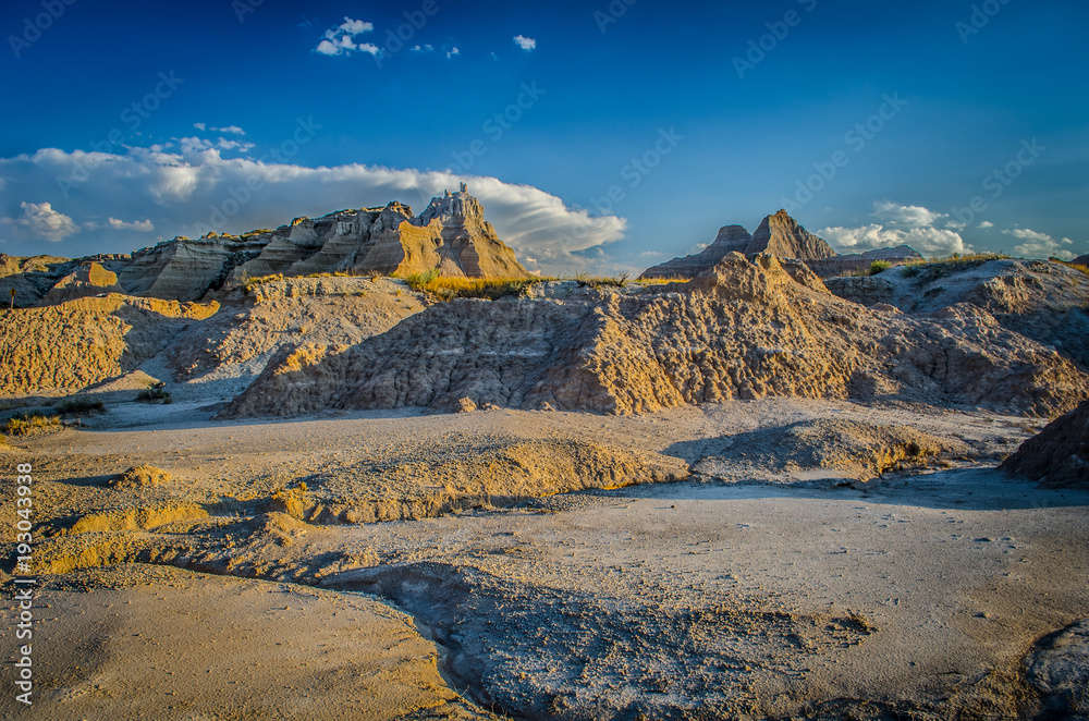 WARM LOW ANGLED SUNLIGHT AND CLOUDS OVER South Dakota BADLANDS