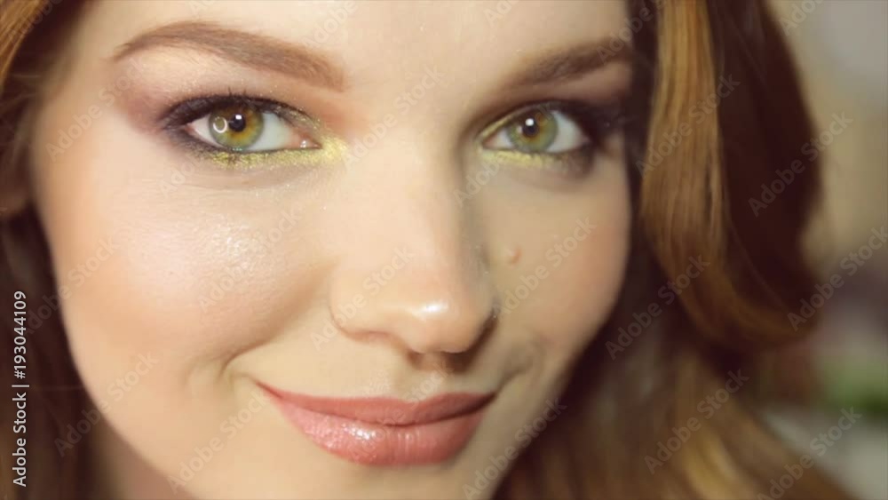 Model poses on camera. Portrait of girl close-up with painted eyes Model poses on camera. Portrait of girl close-up with painted eyes