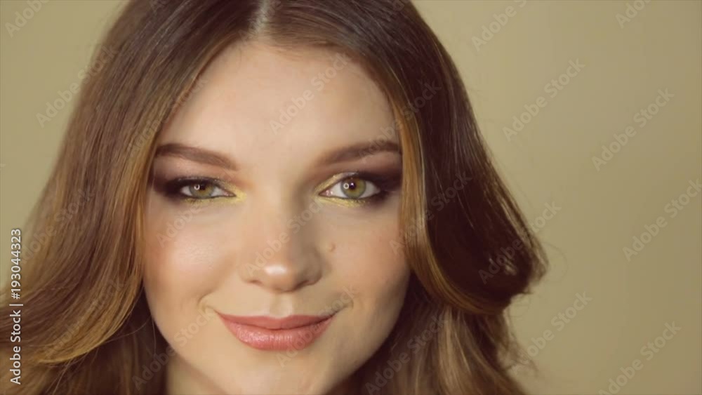 Model poses on camera. Portrait of girl close-up with painted eyes Model poses on camera. Portrait of girl close-up with painted eyes