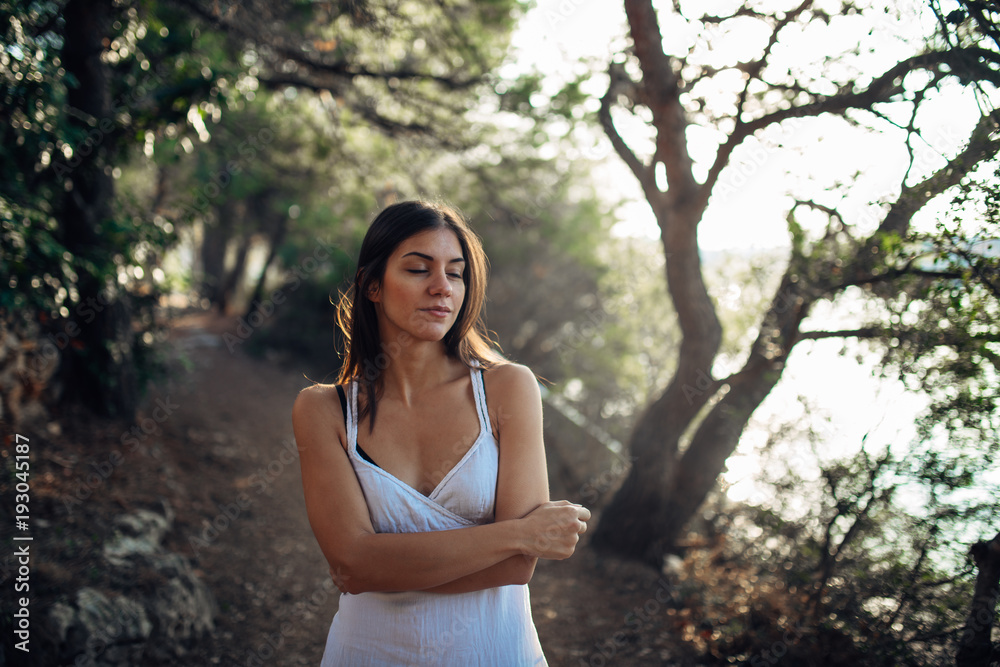 Romantic woman enjoying walk in the nature on a sunny morning.Mindful carefree female in natural environment feeling stress free and relaxed Romantic woman enjoying walk in the nature on a sunny morning.Mindful carefree female in natural environment feeling stress free and relaxed