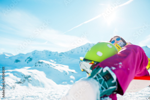Image of sports woman with helmet resting on armchair in winter resort