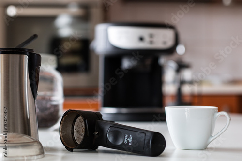 Morning coffee in the kitchen. Coffee grinder and coffee maker with coffee makers on a white kitchen table.