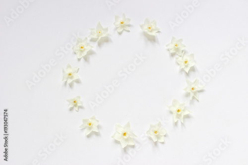 Fototapeta Naklejka Na Ścianę i Meble -  Styled stock photo. Spring, Easter feminine scene floral composition. Round frame wreath pattern made of narcissus, daffodil flowers. White background. Flat lay, top view.