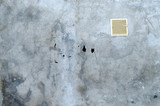 old grey concrete garage wall with spots of black paint with white ventilation grille abstract background