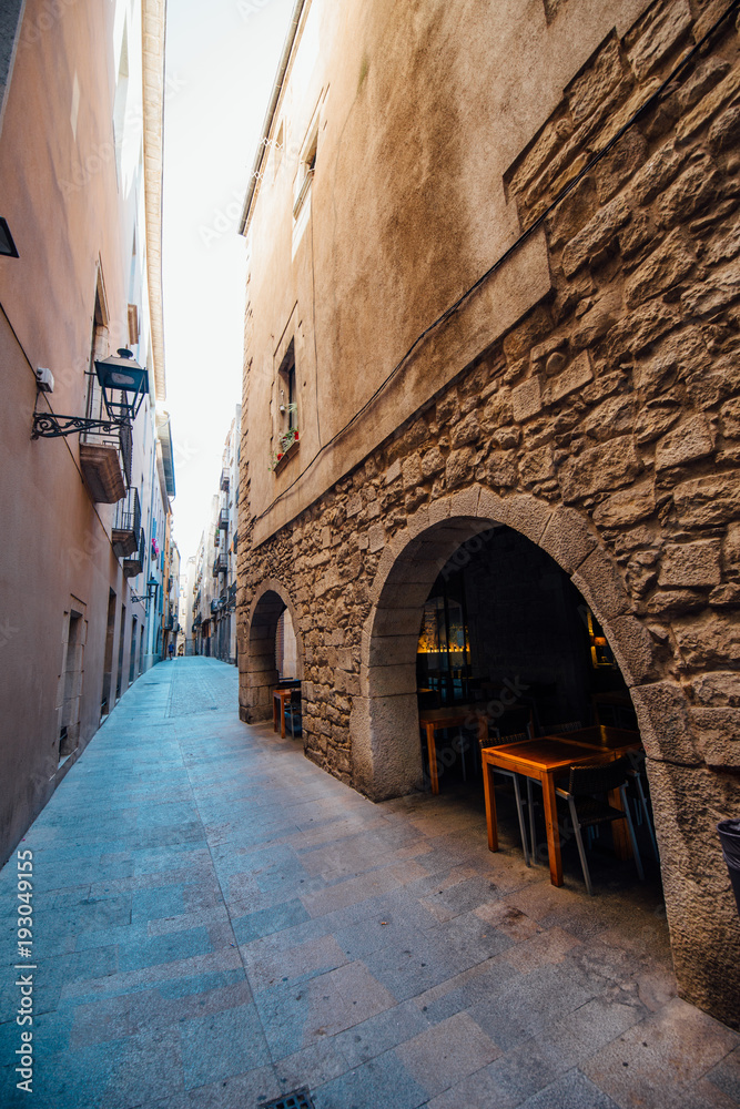 Medieval streets of Girona. Medieval alley with stone walls in Girona.