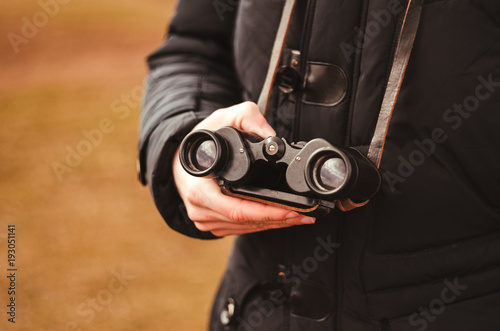 binoculars. close-up. travel and tourism. holds in hand