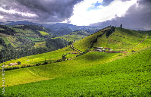 View of a green mountain range, part of the Ecuadorian Andes, with a beautiful sunny and cloudy sky. Cayambe, Ecuador.
