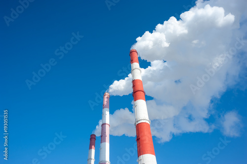 Fotografie Air pollution by smoke coming from three factory chimneys