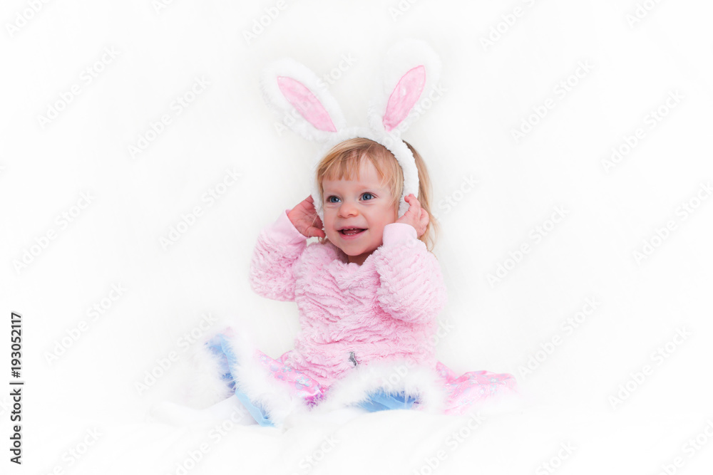 Closeup Portrait of Blonde Baby 18 month old Girl with Big Blue Eyes and Bunny Ears headband, Pink Tutu, isolated on white background. Closeup Portrait of Blonde Baby 18 month old Girl with Big Blue Eyes and Bunny Ears headband, Pink Tutu, isolated on white background.