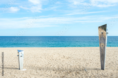 deux petites douches de tailles différente sur une plage avec la méditerranéenne en fond © Olivier Tabary