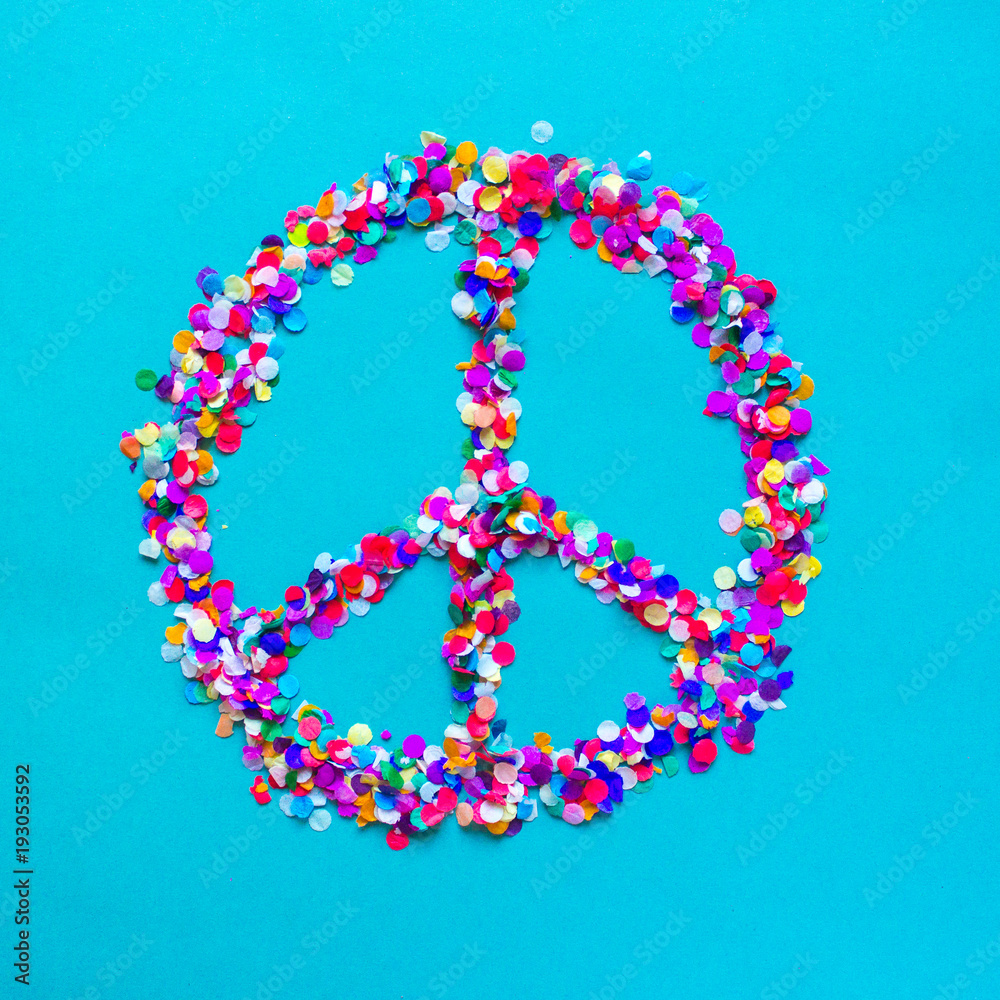 Hippie sign made of colorful confetti on blue background. Bright peace symbol. Hippie sign made of colorful confetti on blue background. Bright peace symbol.