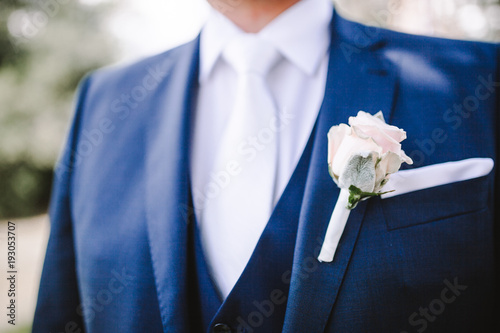Boutonniere on the blue suit jacket of the groom, wedding details