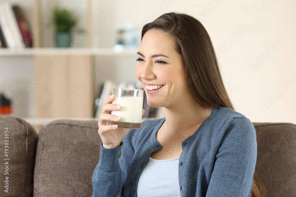 Woman holding a glass of milk on a couch Woman holding a glass of milk on a couch