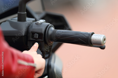 Motorbiker hand starting engine of a motorbike