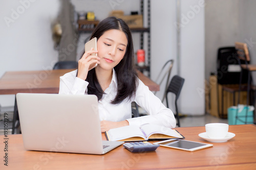 Beautiful asian young businesswoman excited and glad of success with laptop, girl taking mobile phone and working coffee shop on cement background, career freelance business concept.