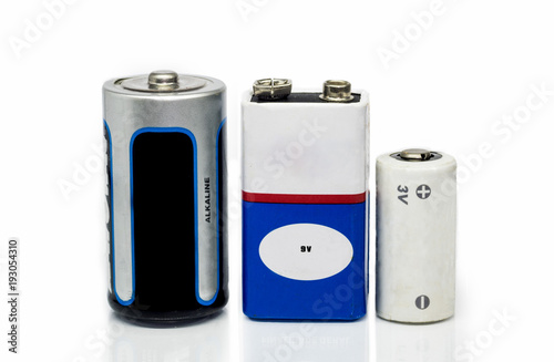 Alkaline batteries, 9v and 3v batteries, isolated on a white background with reflective surface